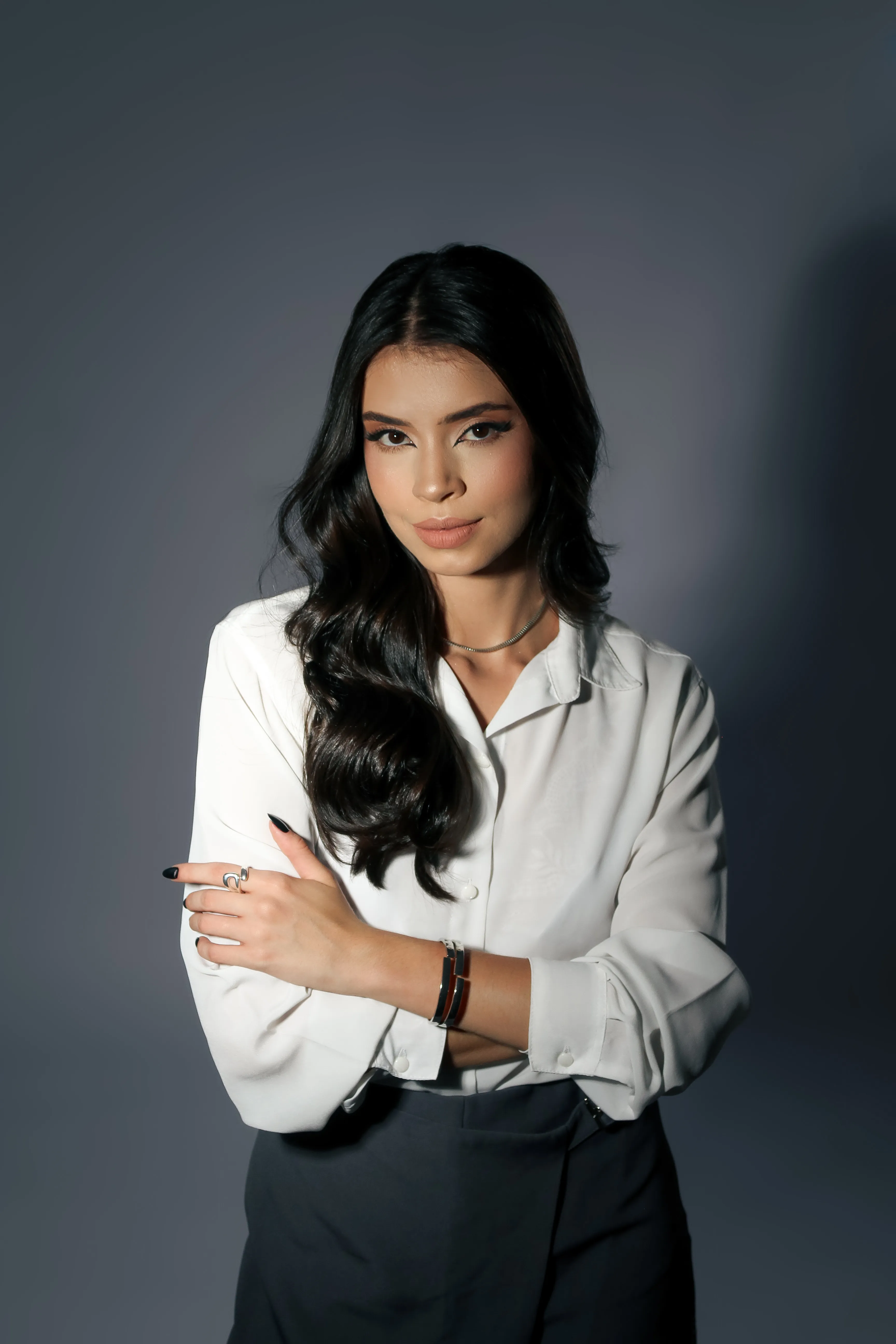 Retrato de mulher com blusa branca e braços cruzados